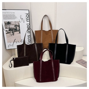 Detail of suede tote bags with rivet accents in brown, tan, black, and wine red