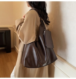 Detail of dark brown tote bag with smooth synthetic leather and small attached pouch