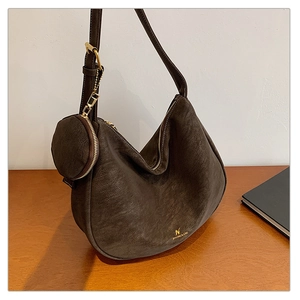 Close-up of matte dark brown hobo bag with a matching coin purse and gold hardware