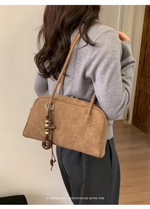 Detail of brown faux suede shoulder bag featuring retro wood beads and a minimalist strap