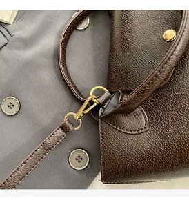 Close-up of luxury brown litchi pattern leather with premium gold hardware buckles
