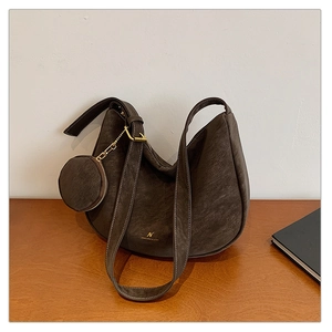 Detail of dark brown matte leather hobo bag with gold hardware and mini coin purse
