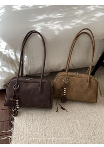 Detail of minimalist retro shoulder bags in dark and light brown with beaded charms