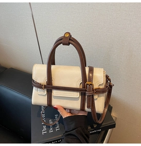 Dettaglio della borsa a tracolla minimalista beige e marrone con fibbia in metallo e texture