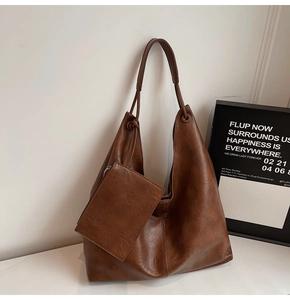 Close-up of brown faux leather tote bag with vintage texture and matching small pouch