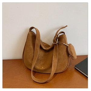 Brown suede hobo bag on a wooden table with matching small zipper coin purse detail