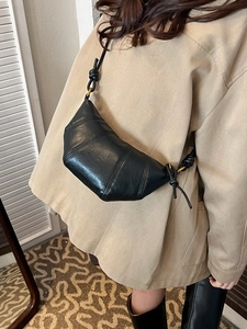 Minimalist black leather croissant shoulder bag with adjustable knotted strap detail