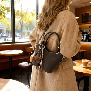 Vintage dark brown bucket bag with wavy edges and star charms shown in a cafe setting
