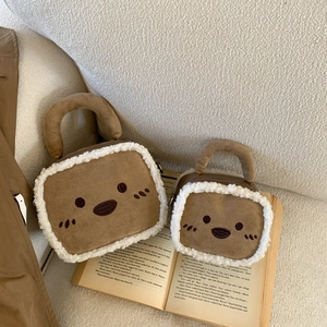 Détail de sacs en daim marron pelucheux avec bordure en peau de mouton blanche et broderie