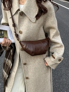 Minimalist dark brown leather croissant bag with quilted design and knotted wide shoulder strap