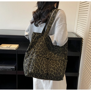 Detail of dark green leopard print canvas tote bag with functional utility pockets
