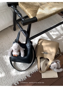 Close-up of minimalist leather bucket bags with silver turn-locks and plush bunny charms