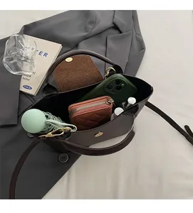 Top view of bucket bag interior showing smartphone, wallet, umbrella, and cosmetics
