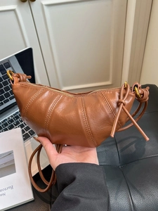 Minimalist brown leather croissant shoulder bag with adjustable strap and stitched details