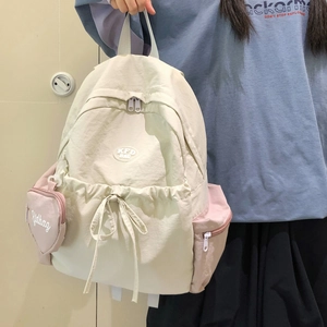 Details eines leichten Nylon-Rucksacks in Creme und Rosa mit herzförmiger Geldbörse