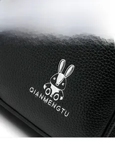 Detail of silver bunny metal logo and lychee grain leather texture on black backpack