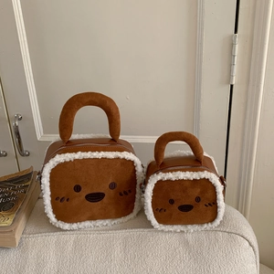 Détail du sac à main en peluche marron avec broderie visage d'ours et bordure blanche
