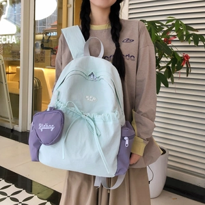 Detail eines mintgrünen Nylon Rucksacks mit lila Herz-Geldbörse und KFD Logo