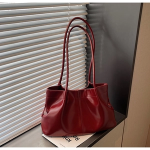 Detailed macro view of retro pleated dark red tote bag with high-gloss leather texture