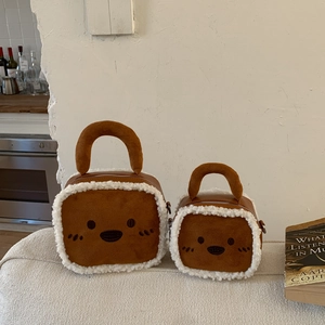 Détail du sac à main en daim caramel et fausse fourrure blanche avec broderie animale
