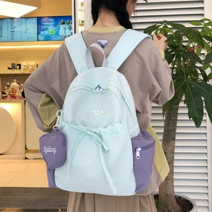 Detailansicht des mintgrün-violetten Rucksacks mit Schleifenkordel und Herz-Anhänger-Zubehör