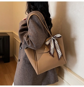 Deep apricot tote bag in lychee leather featuring a geometric scarf and metal buckle detail