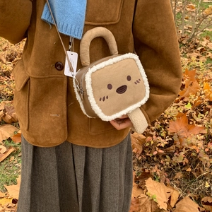 Détail du sac bandoulière créatif en forme de toast avec bords en polaire et broderies