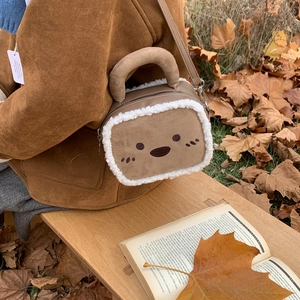 Détail du sac en daim marron avec bordure en polaire blanche et broderie mignonne