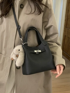 Black lychee leather bucket handbag with silver turn-lock and plush rabbit charm