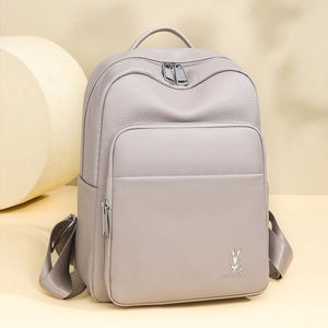 Detailed view of the textured lychee leather and silver zipper on the mauve backpack