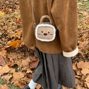 Détail d'un mini sac à bandoulière en forme de toast avec bordure en polaire et broderie