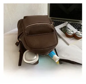 Internal view of minimalist brown leather backpack showing capacity for tablet and accessories