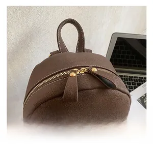 Detail of the high-quality gold zipper and textured brown leather on this retro backpack