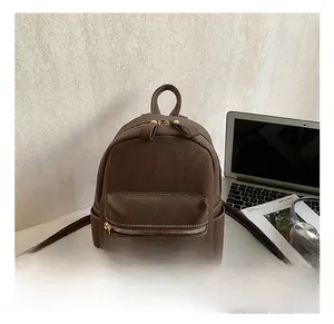 Close-up of brown PU leather backpack with lychee texture and contrast stitching detail