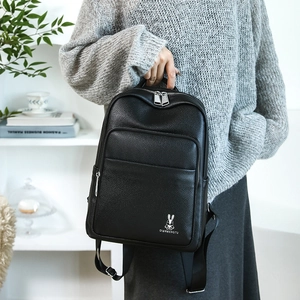 Detail of black pebbled leather backpack with white rabbit logo and zipper pocket