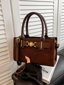 Dark brown suede crossbody bag with heart-shaped buckle and leather top handles