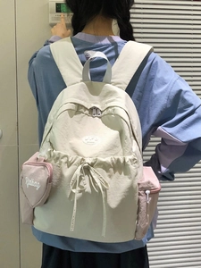 Weißer Nylon-Rucksack mit rosa Seitentaschen und Herzanhänger am Model getragen