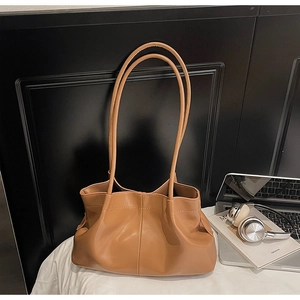 Detail view of large brown pleated faux leather tote bag with stylish shoulder straps