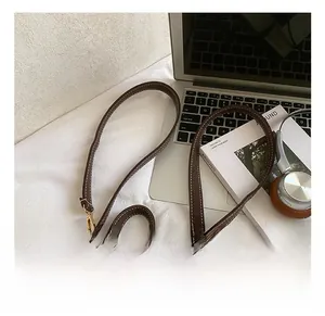 Detail of adjustable shoulder strap with metal buckle and contrast stitching on suede backpack