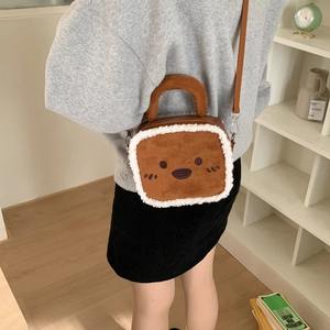Vue détaillée du sac bandoulière en peluche avec visage de dessin animé et fourrure