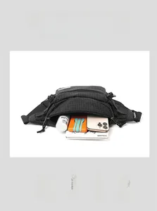 Detail view of black checkered waist bag showing multi-layer compartments and large capacity