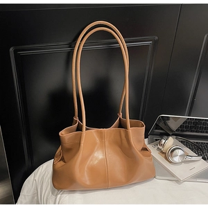 Detail of camel pleated tote bag showing soft PU leather texture and thin shoulder strap