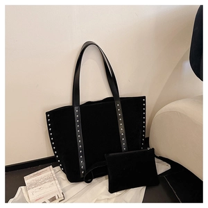 Detail view of black suede tote bag and matching pouch with silver stud accents