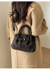 Detail of retro coffee brown tote bag with buckle strap and Fashion logo on wool coat