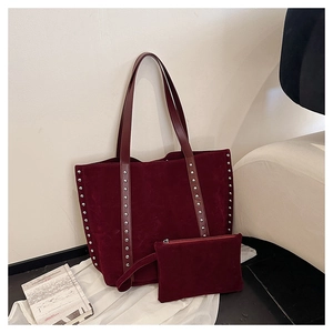 Close-up of burgundy suede tote bag with silver rivet details and matching pouch