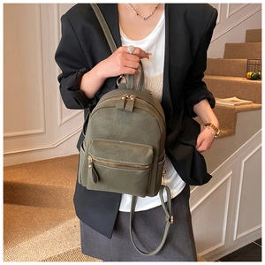 Vue de face d'un mini sac à dos rétro vert olive avec texture vintage sur un mannequin