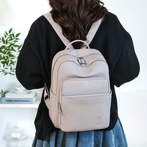 Detail of lavender lilac faux leather backpack with multiple zipper pockets and lychee texture