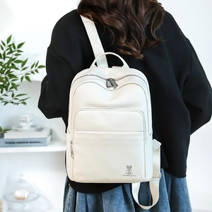 Detail of the ivory white backpack with lychee grain texture and cute rabbit logo