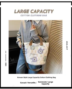 Detail of white quilted tote bag with cat patterns and brown adjustable shoulder strap