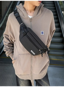 Detail of black mesh texture chest bag with TENGRUN brand strap and durable nylon finish